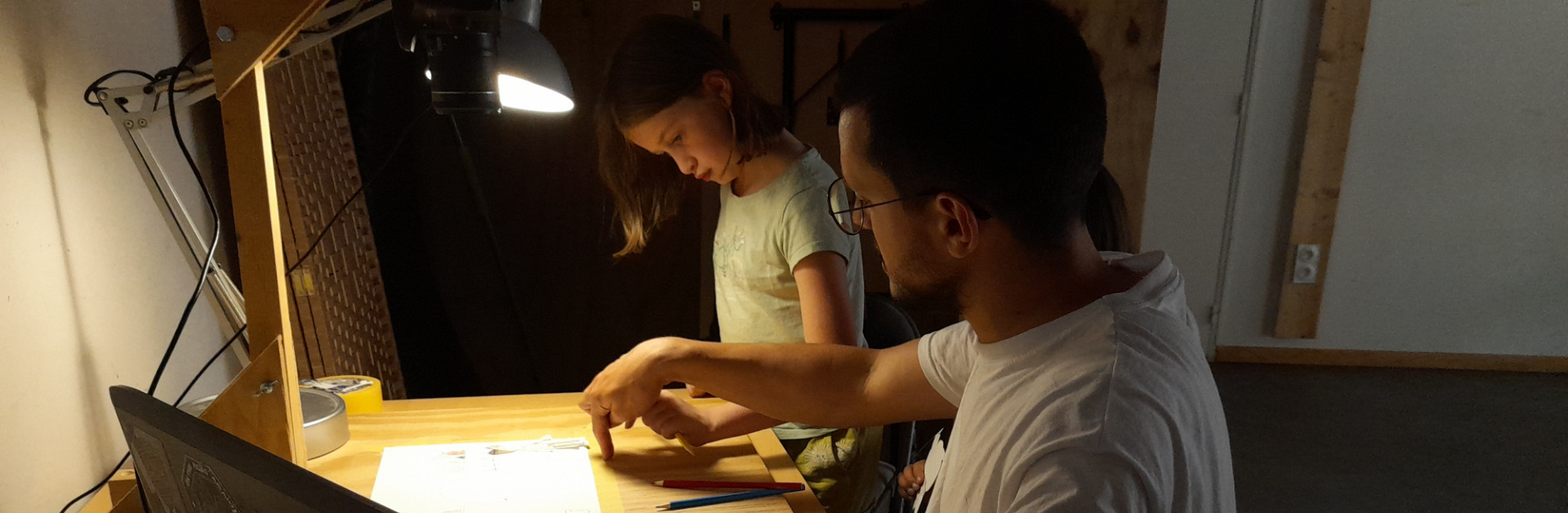 membre du collectif apprenant à dessiner à une enfant