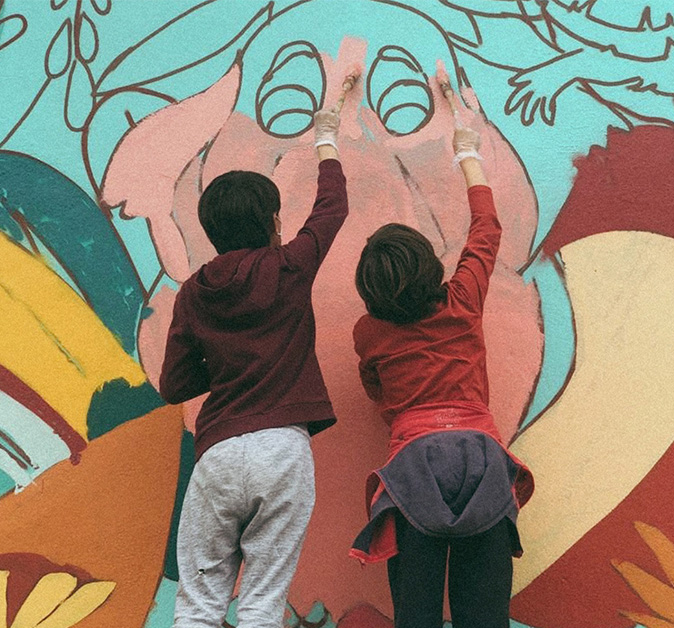 Enfants participants à un atelier de peinture murale en extérieur